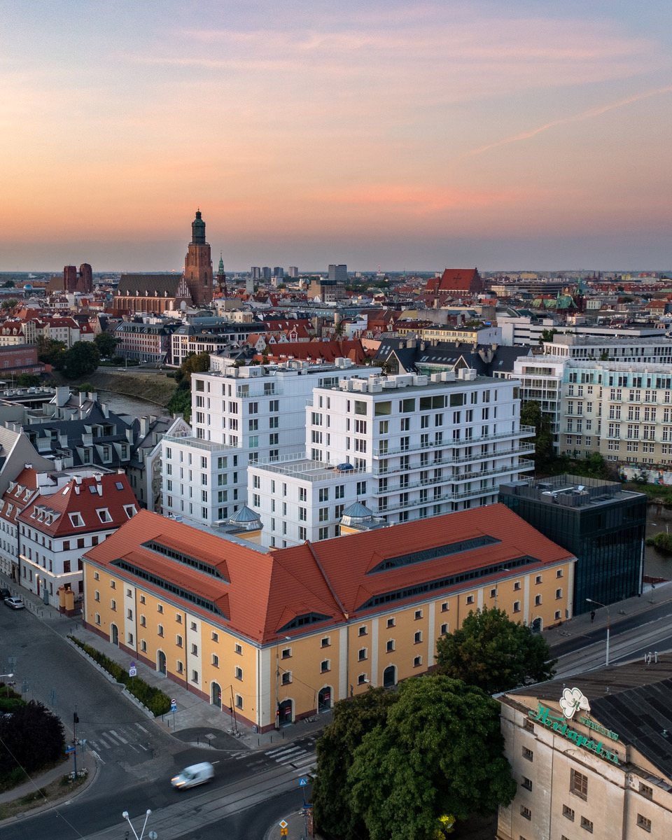 Spichlerz na Kępie Mieszczańskiej o zmierzchu, w tle centrum Wrocławia